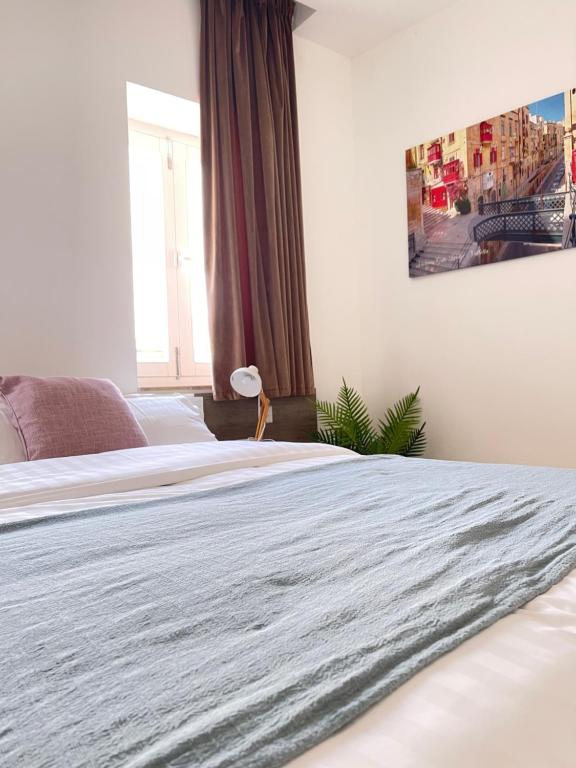 a bedroom with two beds and a large window at Hammock Vibes Town House in Sliema