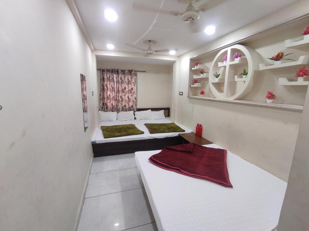a room with two beds and a table in it at Star villa hotel in Ujjain