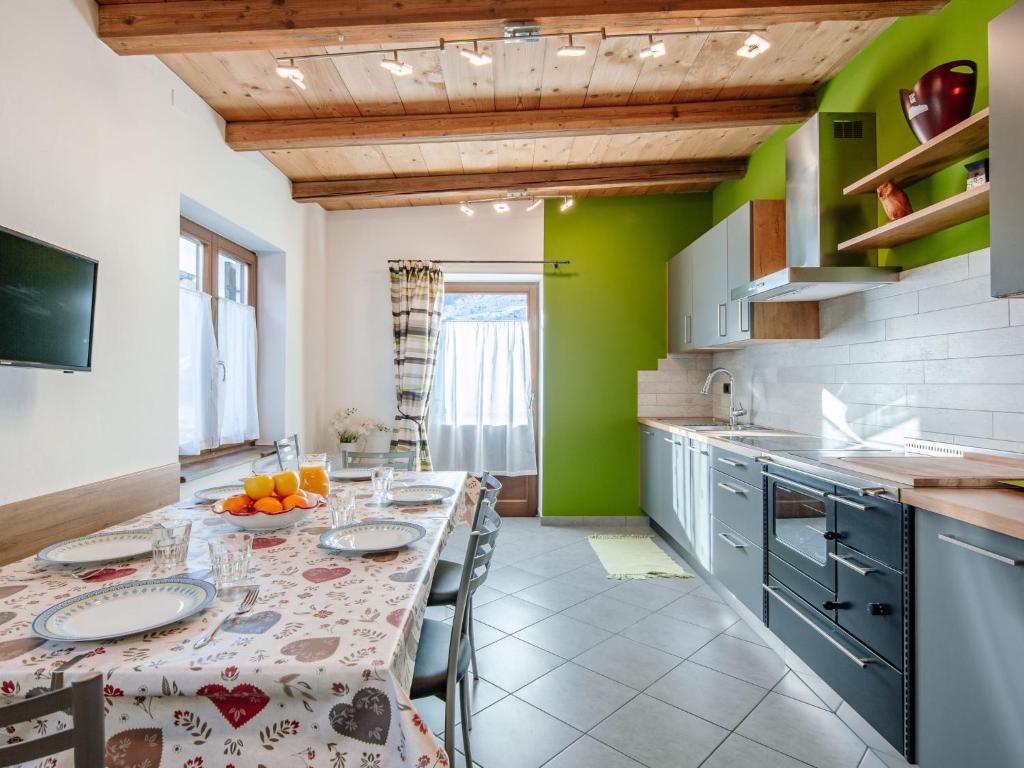 - une cuisine avec une table, des chaises et des murs verts dans l'établissement Apartment Casa Marta by Interhome, à Canazei