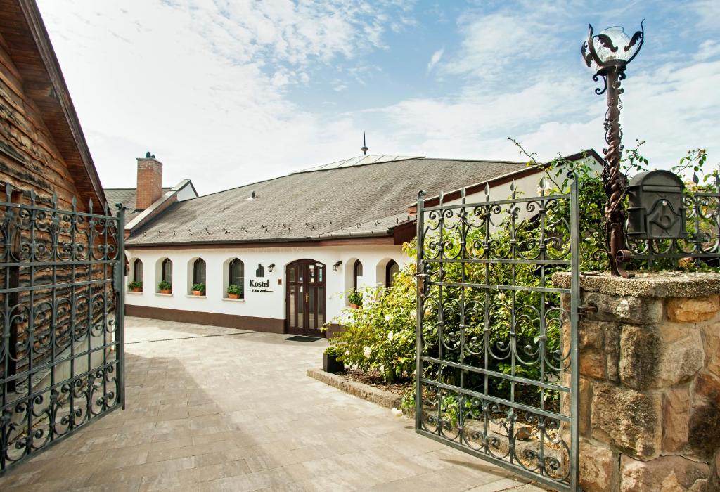 einen Eingang zu einem Haus mit einem Tor und einem Gebäude in der Unterkunft Kostel Panzió in Kesztölc