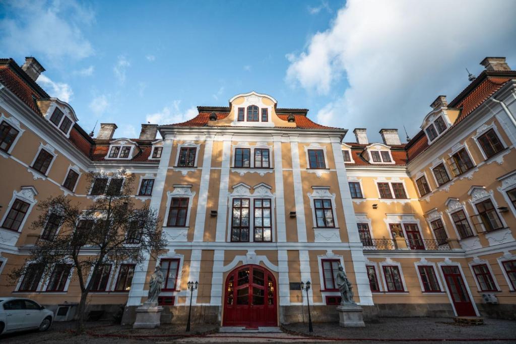 un gran edificio con una puerta roja en Zámek d´Este, en Chlum u Třeboně