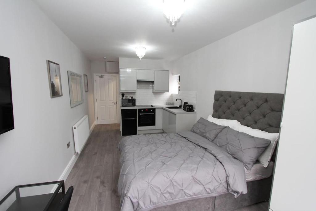um pequeno quarto com uma cama e uma cozinha em New Cosy Studio in London! em Londres