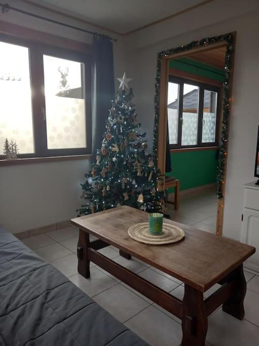 a living room with a christmas tree and a wooden table at Chalet - l&#39;Endoxyle in Froid-Chapelle