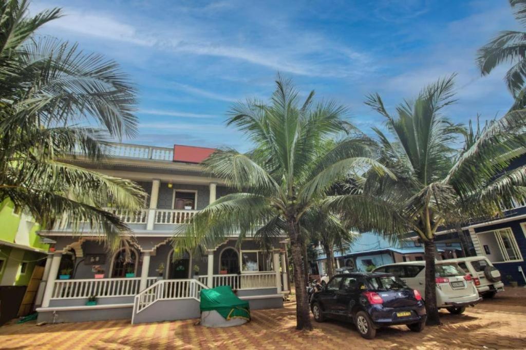 a house with palm trees in front of it at Roseal Water Front in Baga