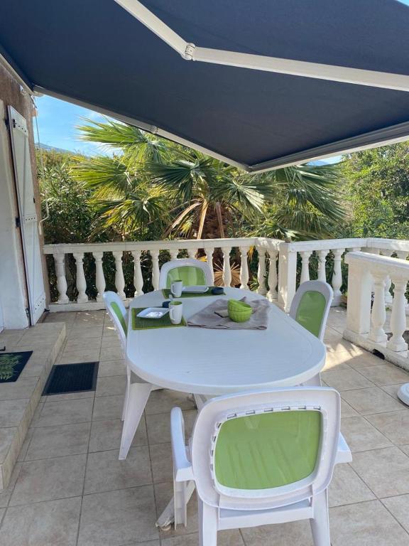 une table blanche et des chaises sur une terrasse dans l'établissement Appartement T2 Olmeto, à Olmeto