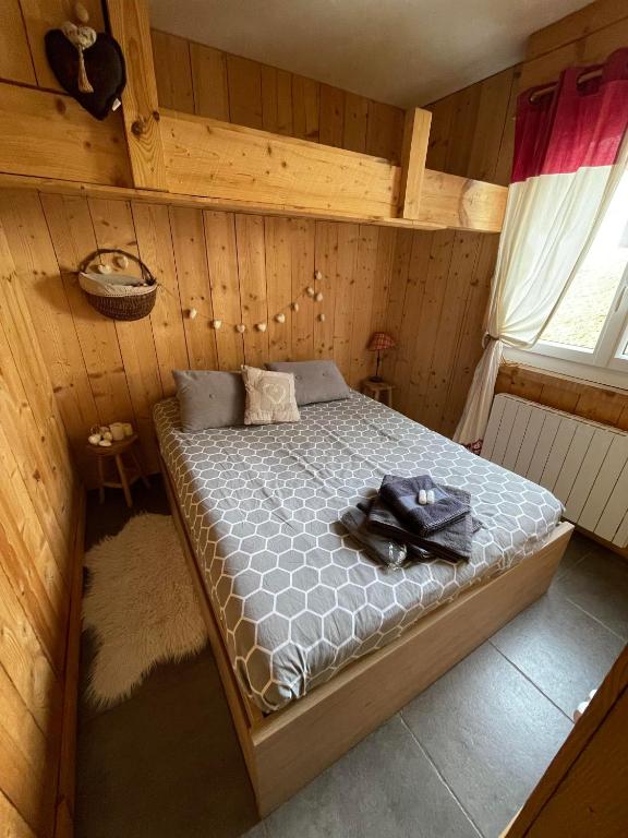 une chambre avec un lit dans une pièce en bois dans l'établissement Logicoeur, à Gérardmer