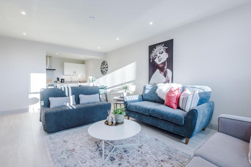 a living room with two blue couches and a table at Stunning Flat in Central Leeds by PureStay Short Stays in Leeds