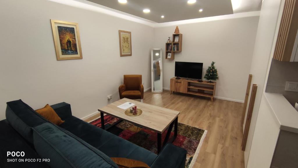 uma sala de estar com um sofá, uma mesa e uma televisão em Apartman Noel Sarajevo em Sarajevo