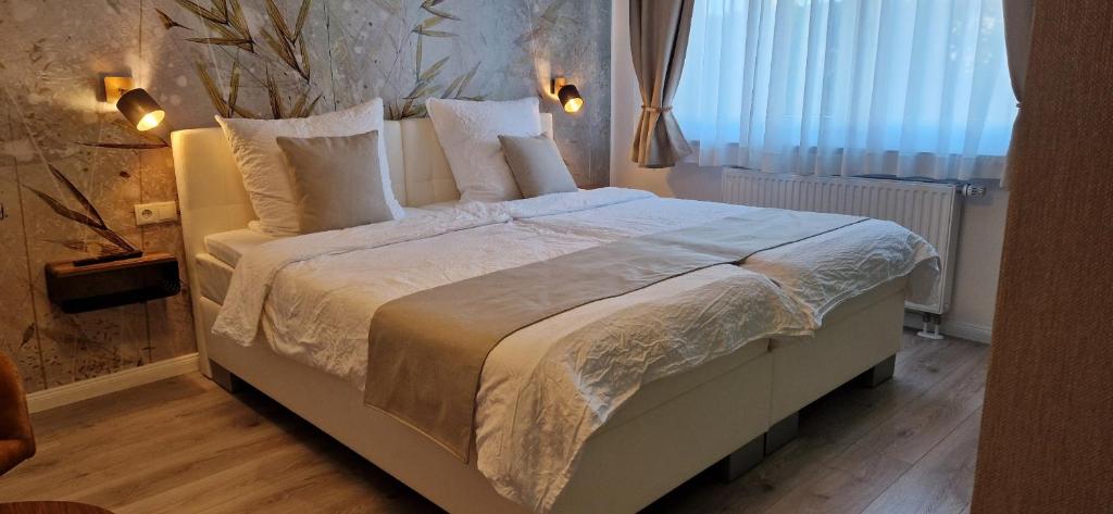 a bedroom with a large bed with white sheets and pillows at Bergische Idylle in Overath