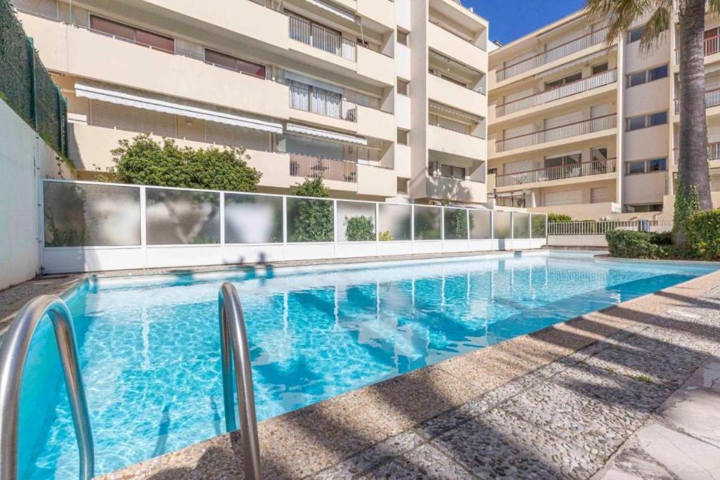 a swimming pool in front of a building at Cap d'Antibes Studio et terrasse face à la mer in Antibes