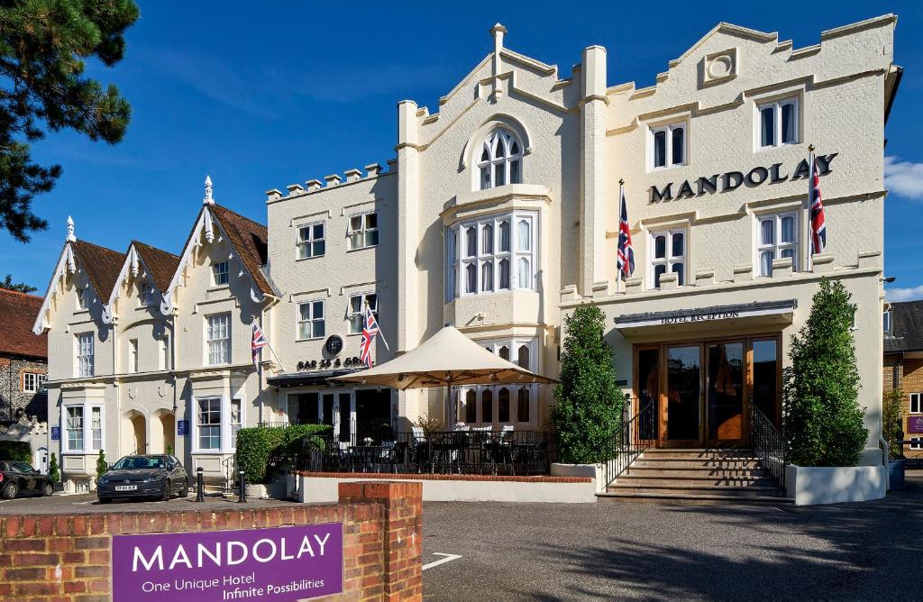 un gran edificio blanco con un cartel delante en Mandolay Hotel Guildford en Guildford