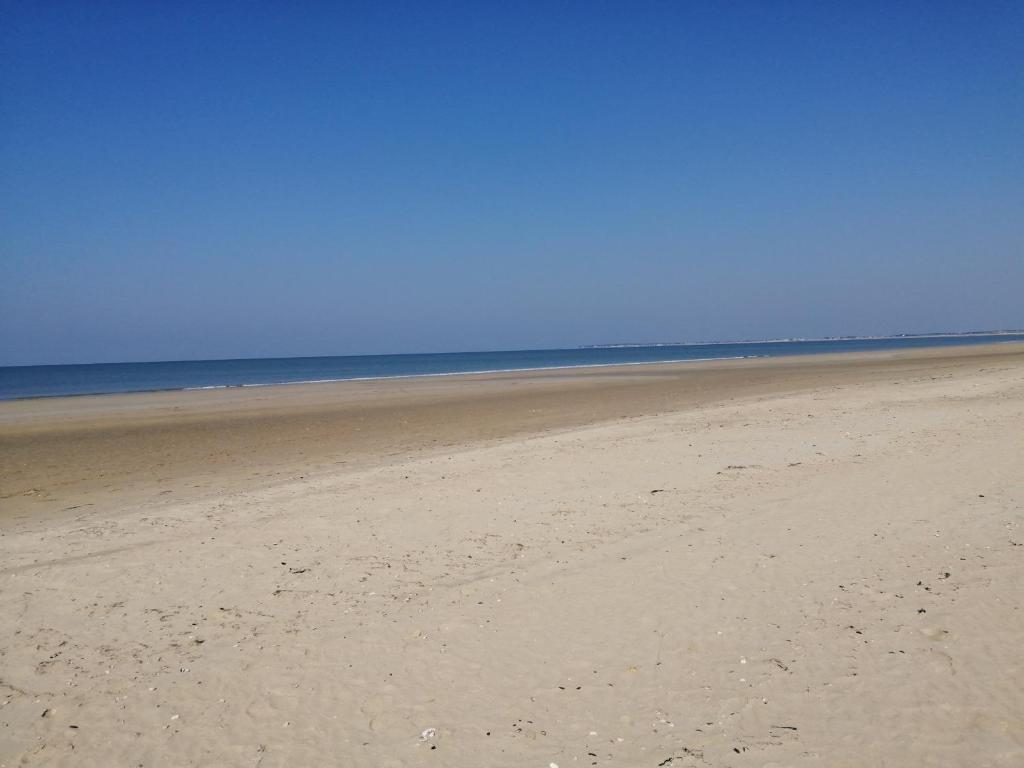 une plage de sable avec l'océan en arrière-plan dans l'établissement Dormez au coeur du village entre plage et polder, à Barbâtre