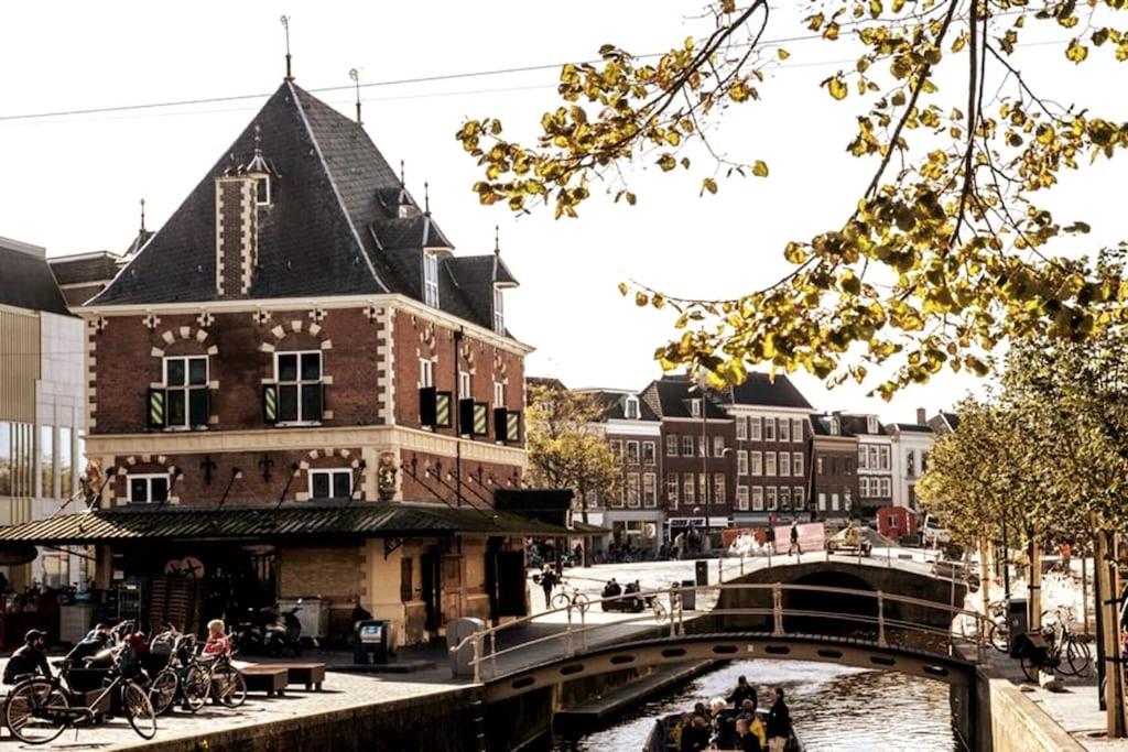 un edificio junto a un río con un puente en Appartement met prachtig uitzicht over de binnenstad van Leeuwarden en Leeuwarden