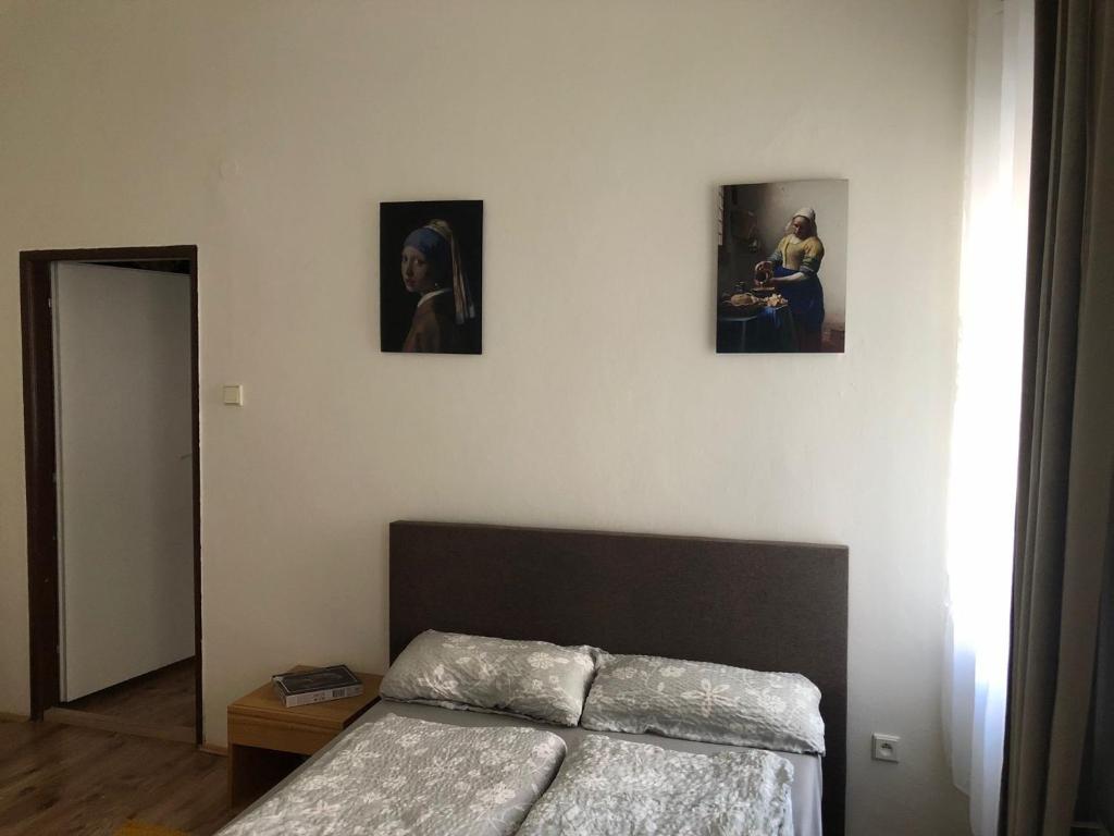 a bedroom with a bed and three pictures on the wall at Nette Wohnung in der Altstadt 2 in Cheb
