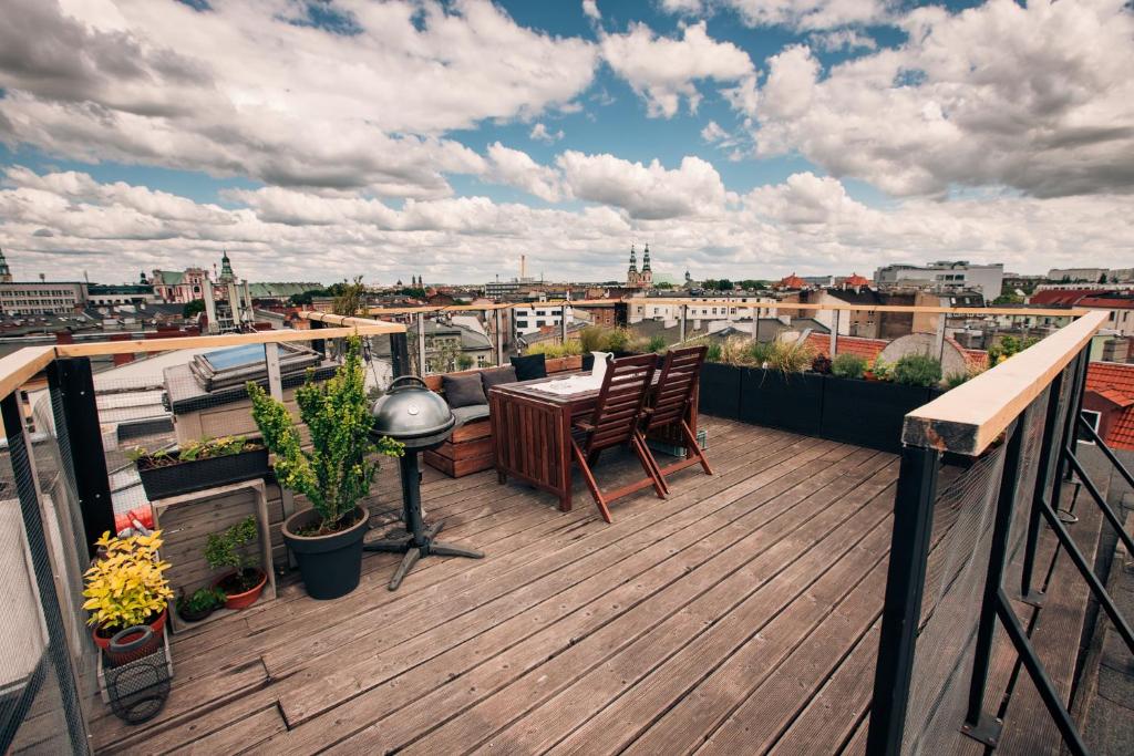 a balcony with a table and chairs on a roof at Apartment with a roof terrace in Poznań