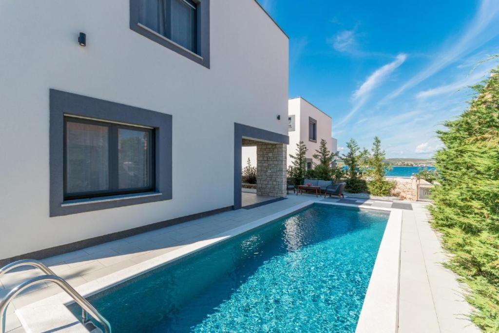 a swimming pool in the backyard of a house at Royal House 3 in Pašman