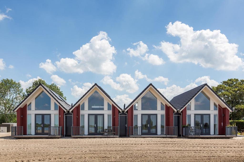 a row of four houses in front of a field at Dormio Waterpark Langelille in Langelille