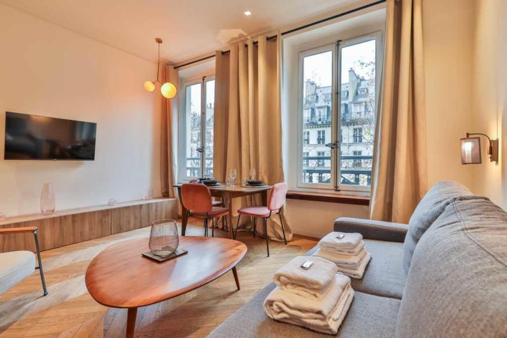 un salon avec un canapé et une table dans l'établissement CMG Résidence Galeries Lafayette - Madeleine, à Paris