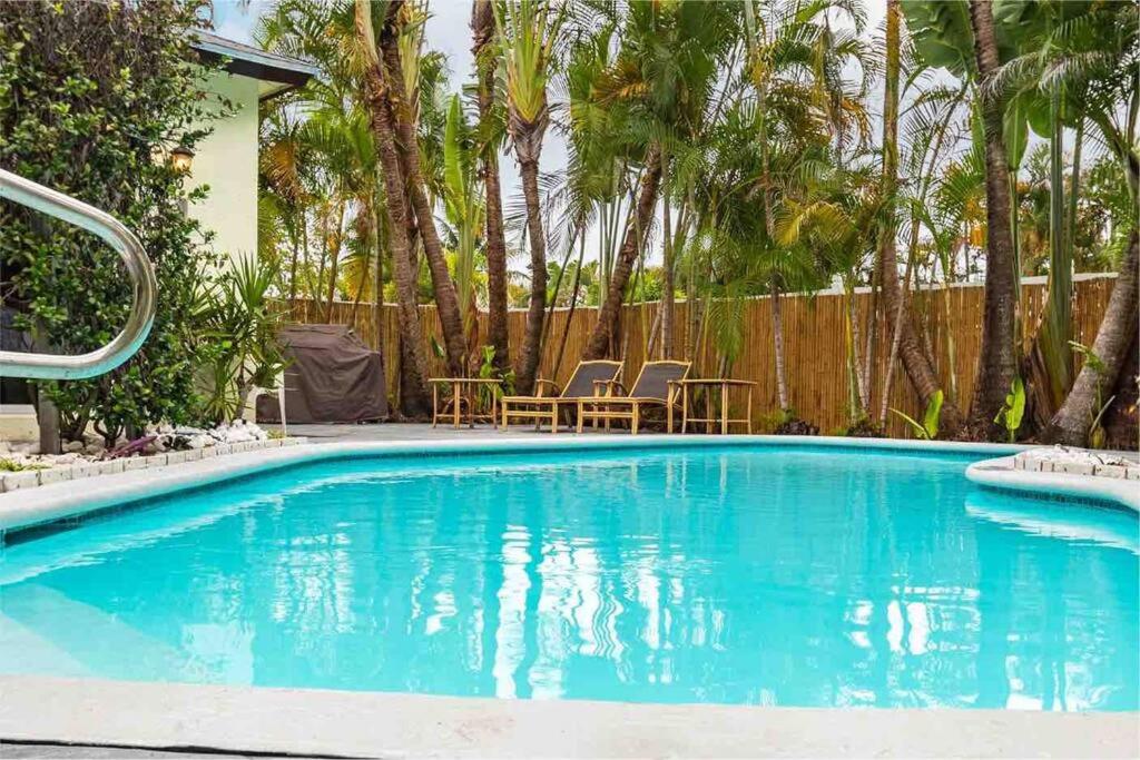 a swimming pool with blue water in a yard at Tropical Oasis with Heated Pool in Boynton Beach