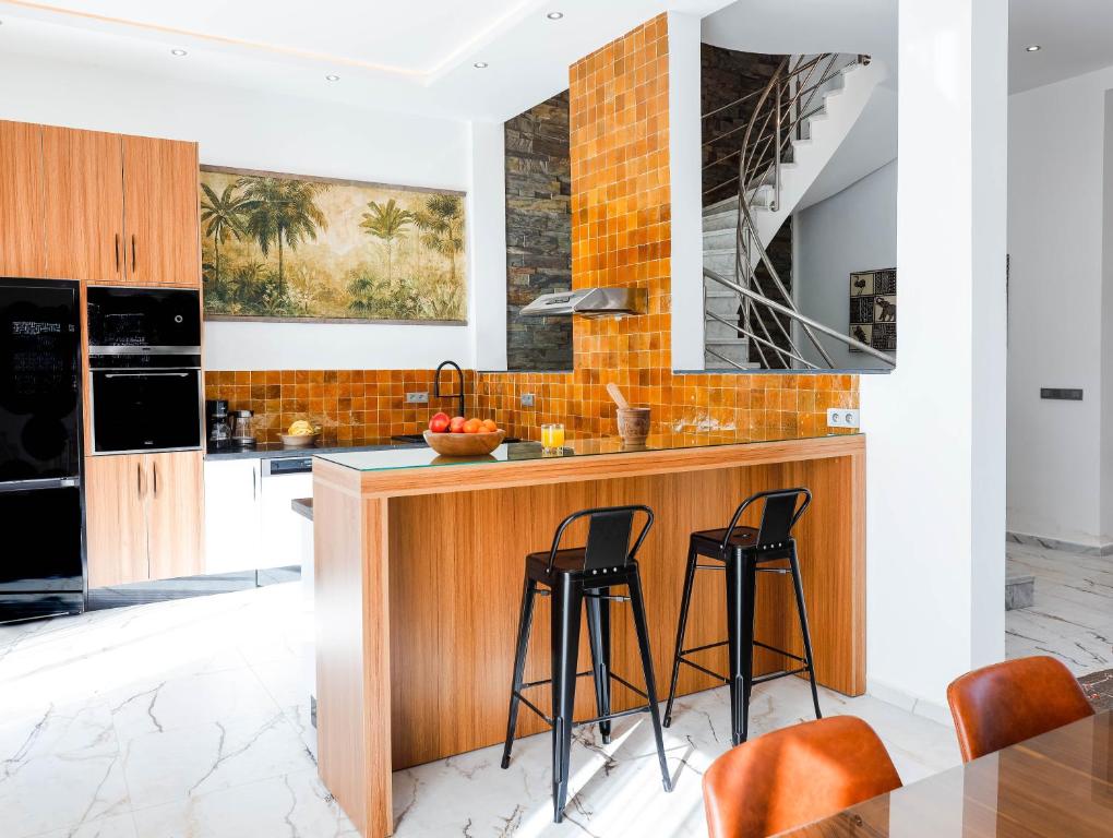 a kitchen with a wooden counter and stools at Villa Africa in Essaouira
