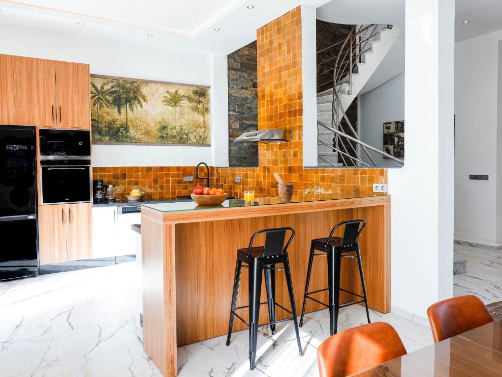 cocina con encimera de madera y taburetes en Villa Africa, en Essaouira