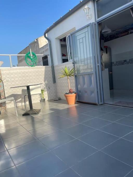 a patio with a table and a door on a house at Appartement- Terrasse sublime in El Jadida
