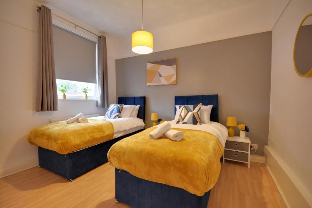 1 dormitorio con 2 camas y ventana en Luxurious and Roomy 2-BD Apartment - Free Parking, en Wallasey