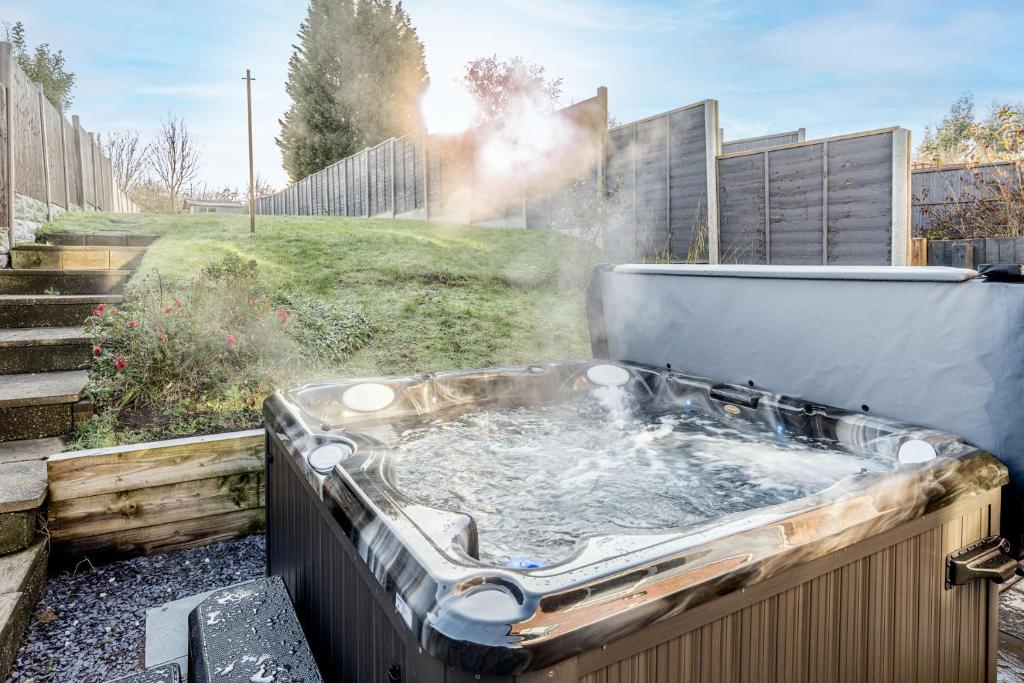 a hot tub in a garden with water in it at Ridge Grove Lodge "Sleeping 4 guests" 