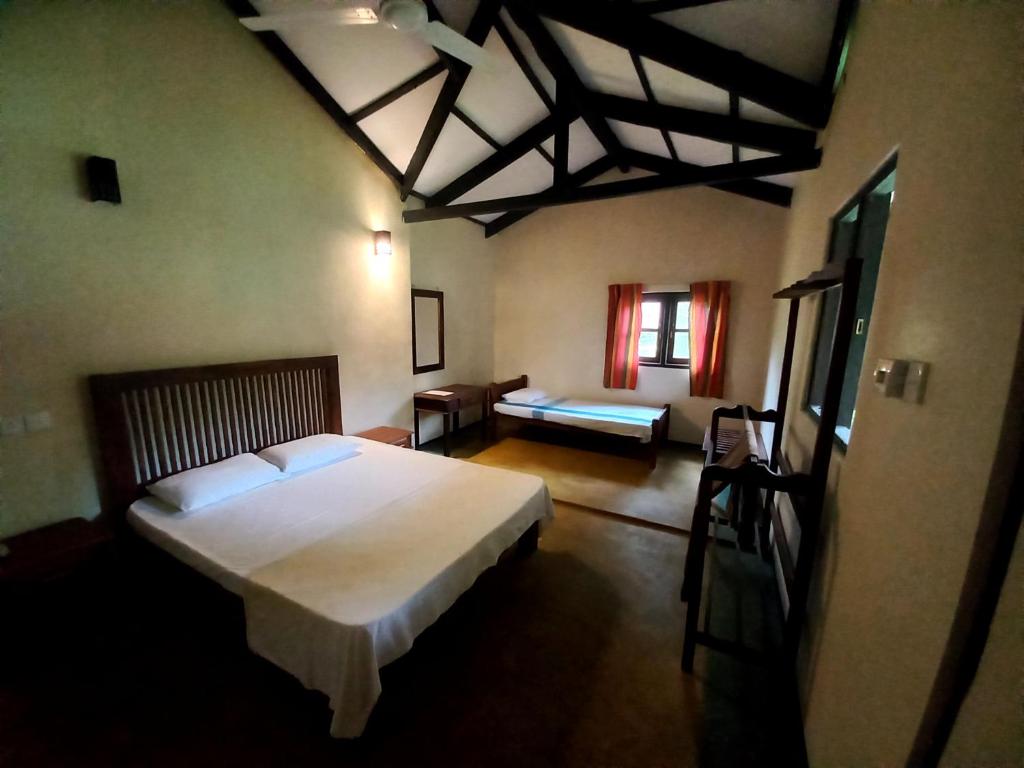 a bedroom with a large white bed and a couch at Ralapela Eco Resort in Tangalle