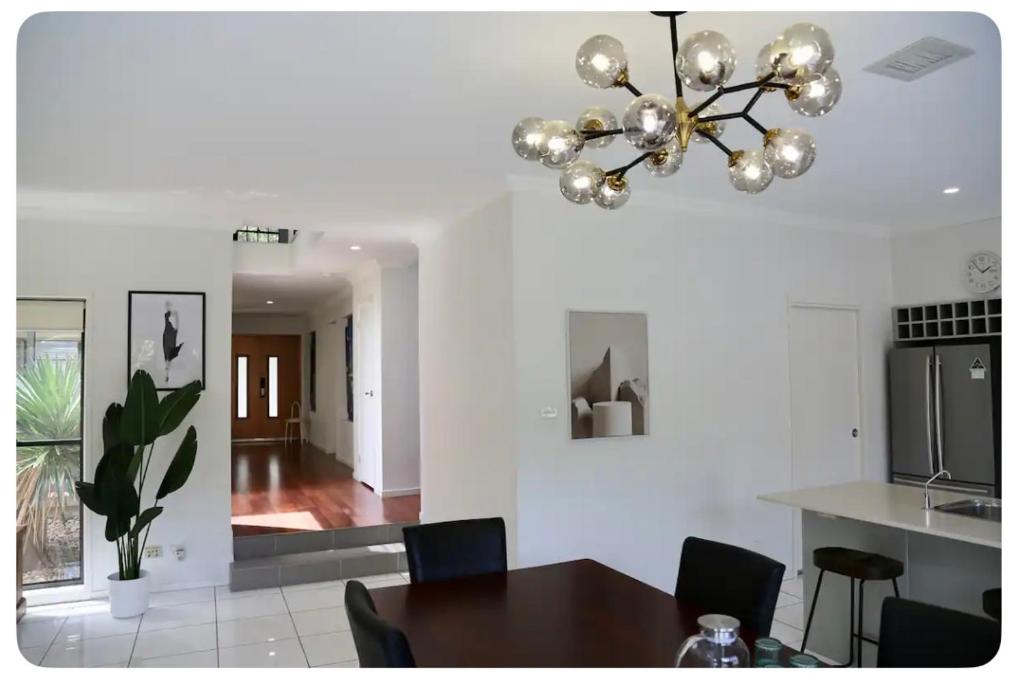 a dining room with a table and a chandelier at Balgowlah as home in Sydney