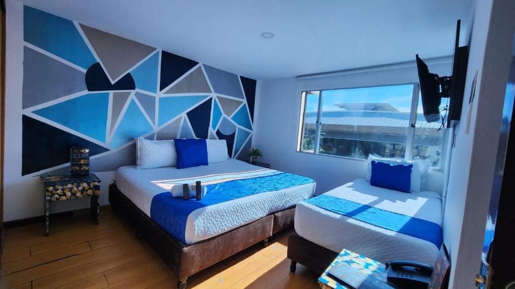 a bedroom with two beds and a large window at Hotel Blue Zafiro in Bogot&aacute;