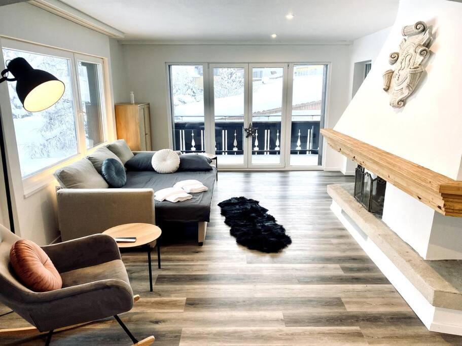 ein Wohnzimmer mit einem Sofa und einem Kamin in der Unterkunft Modern designed, luxury mountain view Apartment in Kandersteg