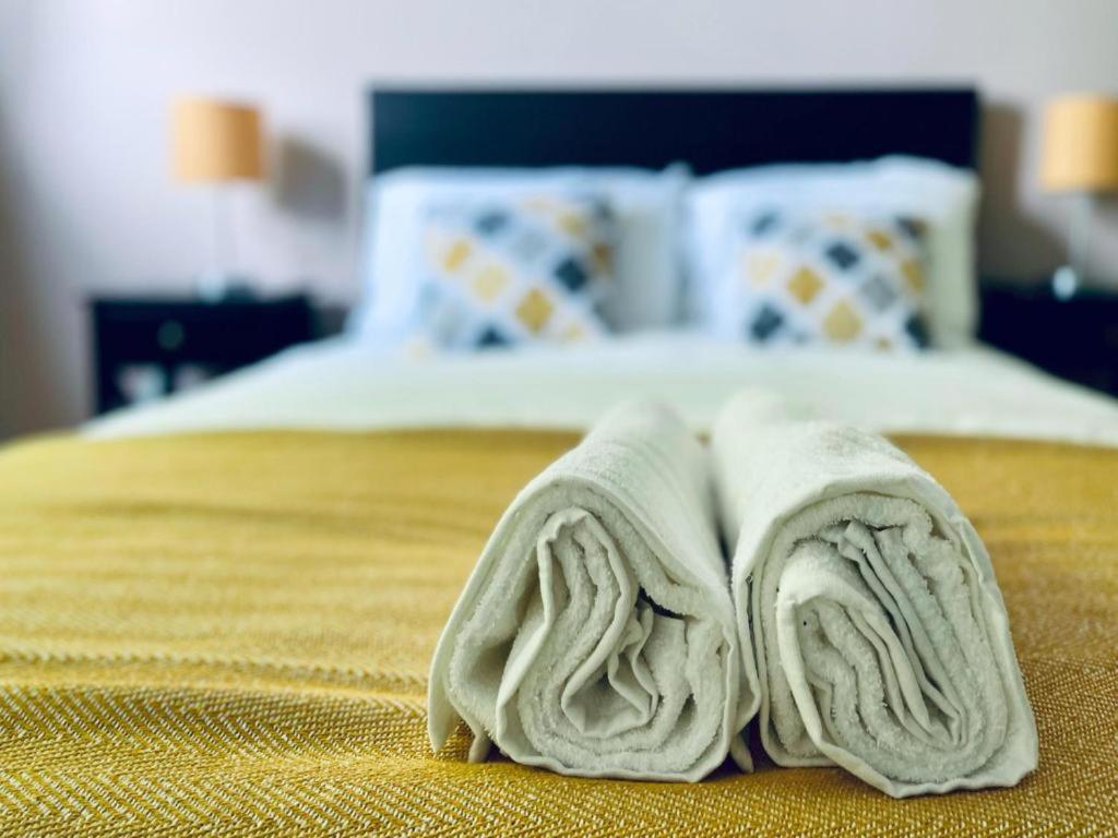 a pile of towels laying on top of a bed at Tom's Place in Mile End in London