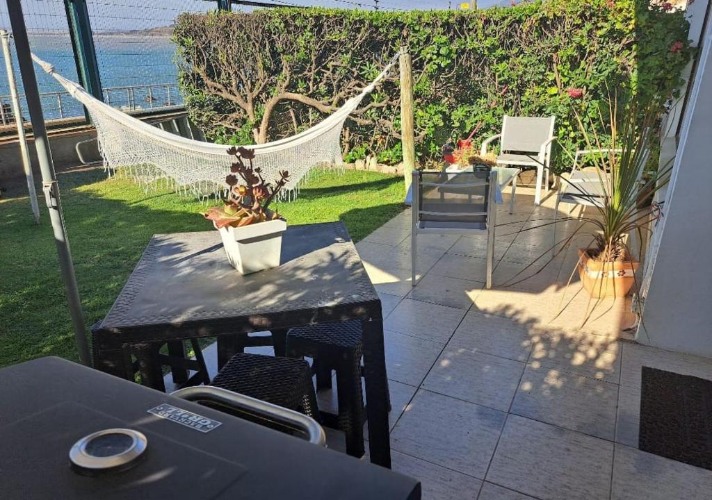 a patio with a hammock and a table and chairs at La Marina home in Concón