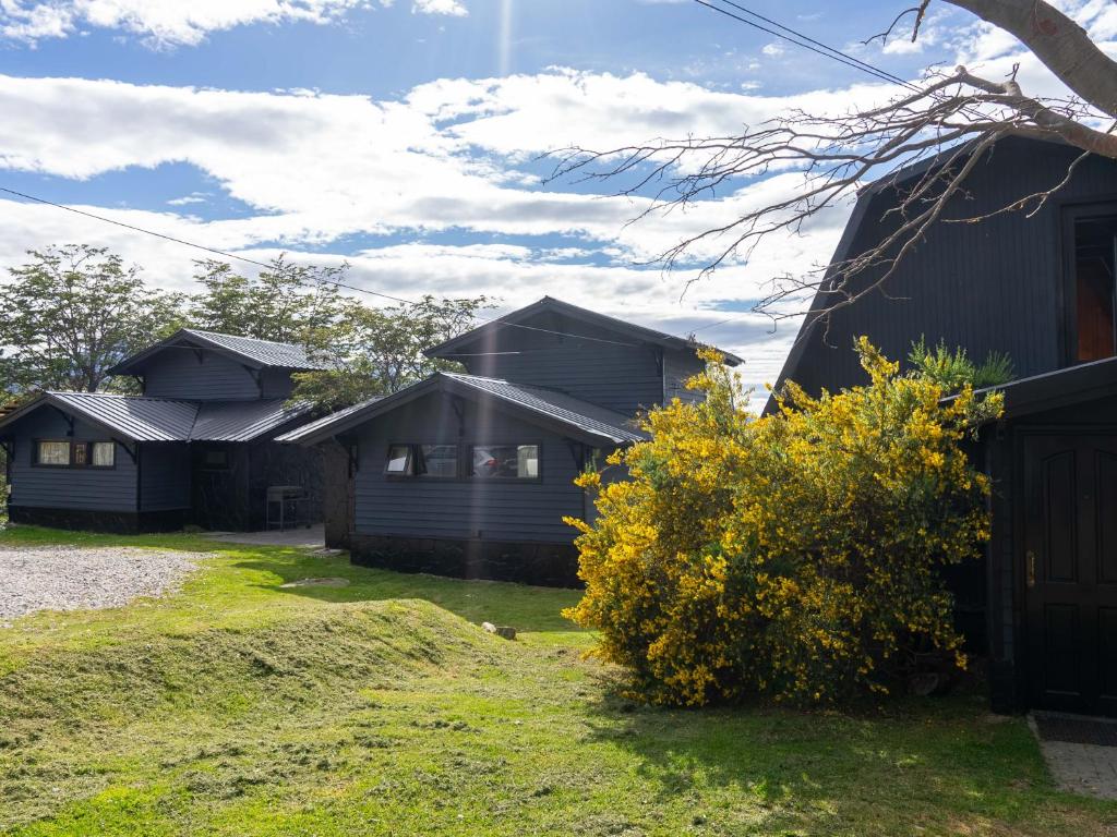 uma fila de casas rústicas ao lado de um quintal em Utaka Cabañas y Apartamentos em Ushuaia