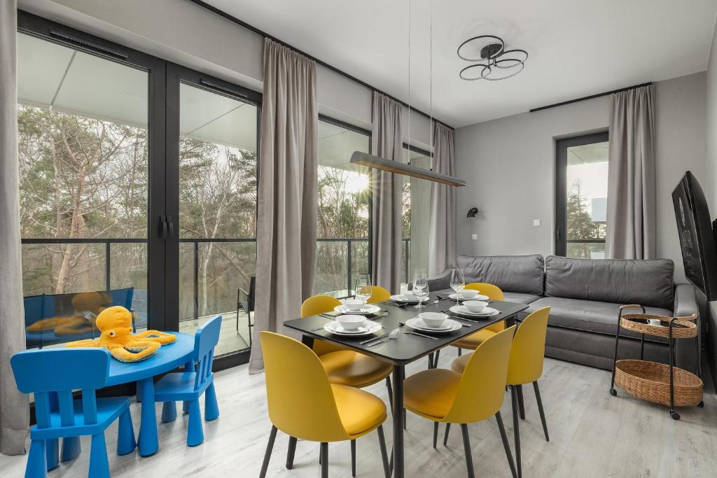 a dining room with a table and chairs and a couch at Shellter Apartments Villas - by Jantar Apartamenty in Rogowo