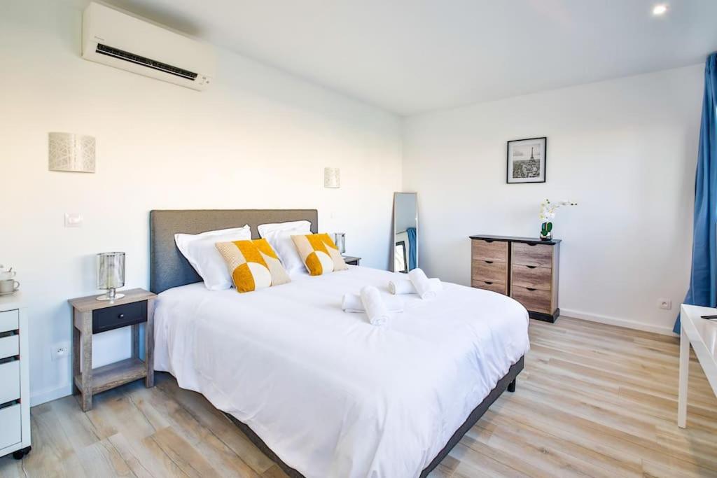a bedroom with a large white bed with yellow pillows at Studio Design Près du Metro in Montrouge