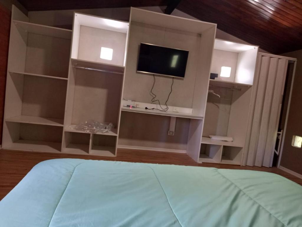 1 dormitorio con TV y 1 cama en una habitación en Cabañas LUNALUMA en Barrancas