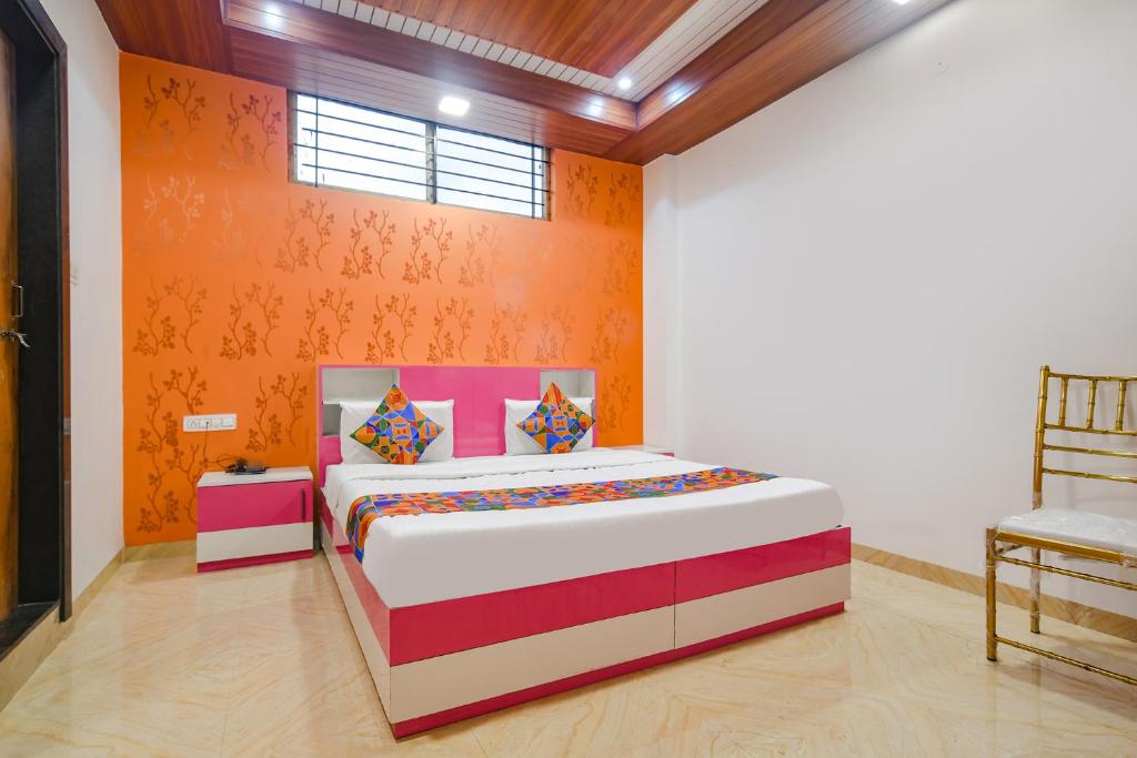 sypialnia z łóżkiem z pomarańczową ścianą w obiekcie FabExpress Dream paradise w mieście Indore