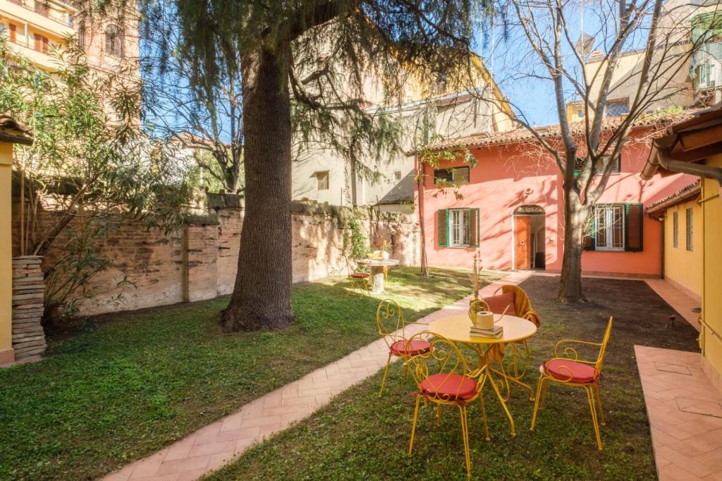 einen Tisch und Stühle im Hof eines Hauses in der Unterkunft [Piazza Maggiore] Il Sentiero - Villa with garden in Bologna
