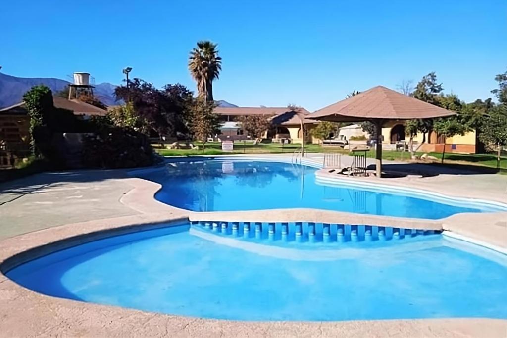 een zwembad in een resort met blauw water bij Habitaciones Tahiken in Olmué