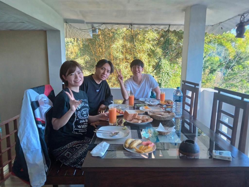 três pessoas sentadas à mesa a comer comida em Pleasant View Ella em Ella