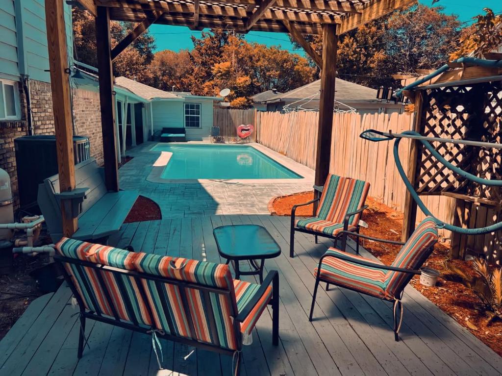 a deck with chairs and a swimming pool at Home for summer with pool, pool table, outdoor kitchen,patio and balcony in Houston