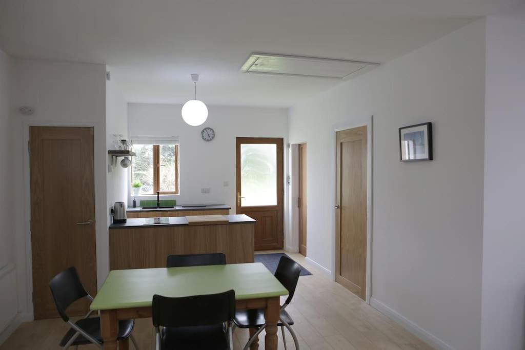 uma cozinha e sala de jantar com uma mesa verde e cadeiras em Spacious modern one bedroom apartment em Galway