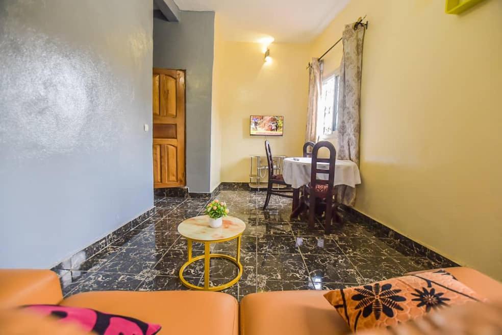 uma sala de estar com um sofá e uma mesa em Résidence Chic & Luxueux MD & NG à Bafoussam em Bafoussam