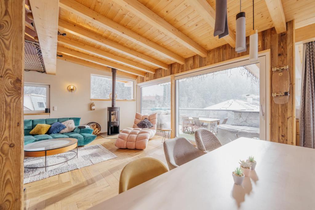 ein Wohnzimmer mit Holzdecken und einem großen Fenster in der Unterkunft DMG - 'The Luxury Penthouse' in Fulpmes