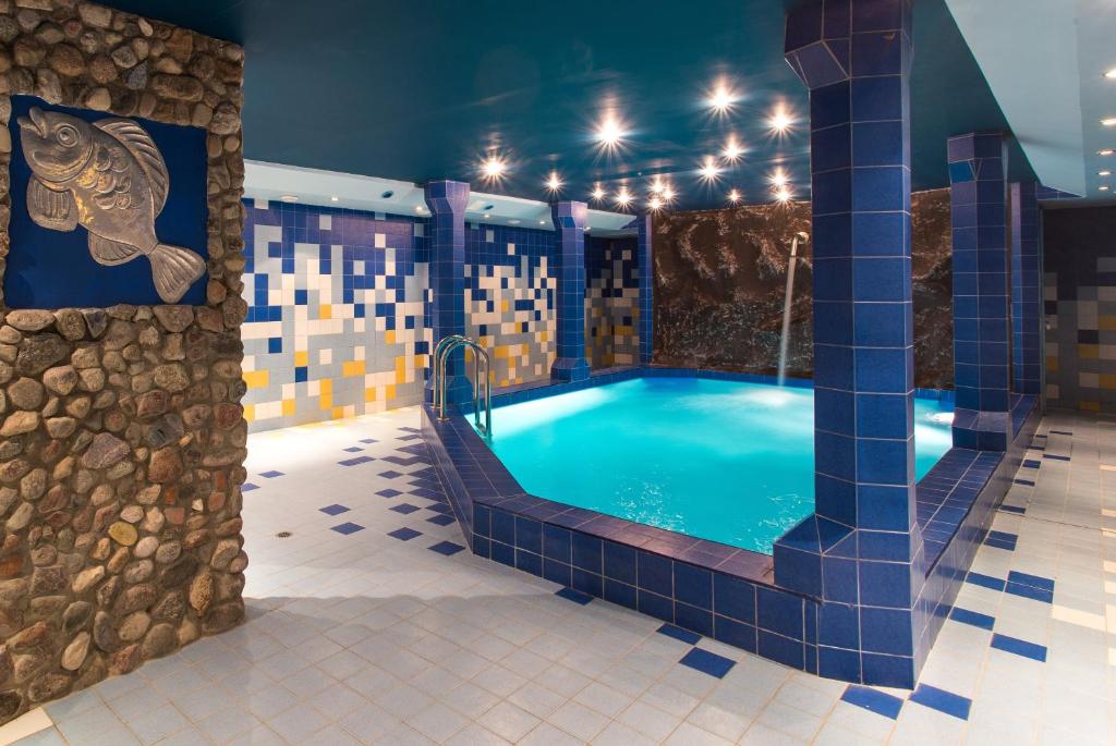 uma piscina olímpica num quarto com piso em azulejo azul em Galia em Druskininkai