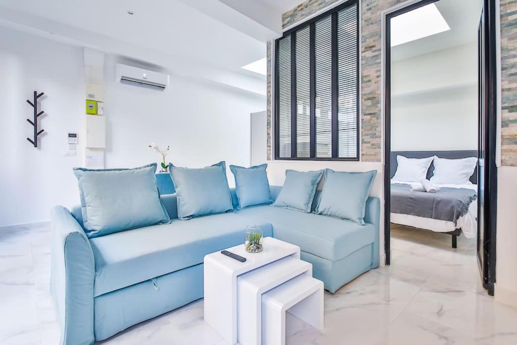 ein Wohnzimmer mit einem blauen Sofa und einem Tisch in der Unterkunft Beautiful Appartment 6 Peoples in Montrouge