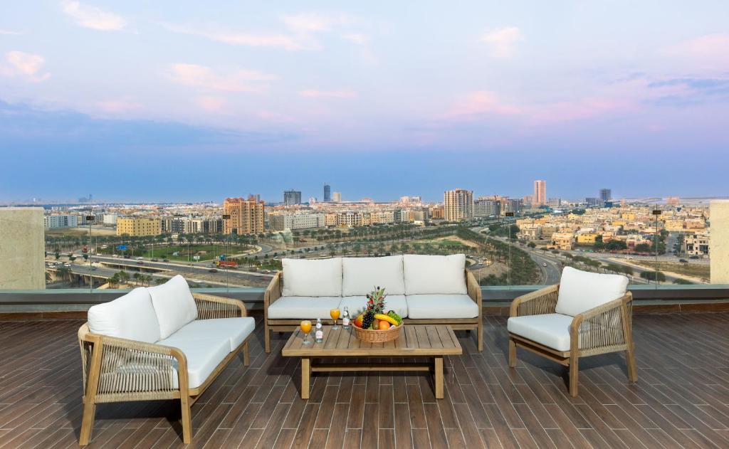 a balcony with white furniture and a view of a city at Mirot Residence in Al Khobar