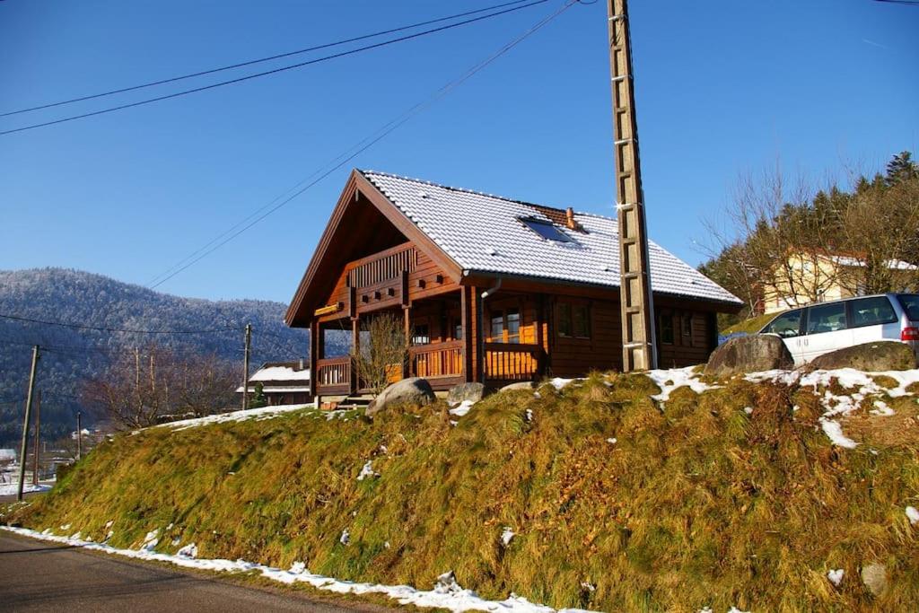 a house sitting on top of a grassy hill at véritable chalet finlandais in Basse-sur-le-Rupt